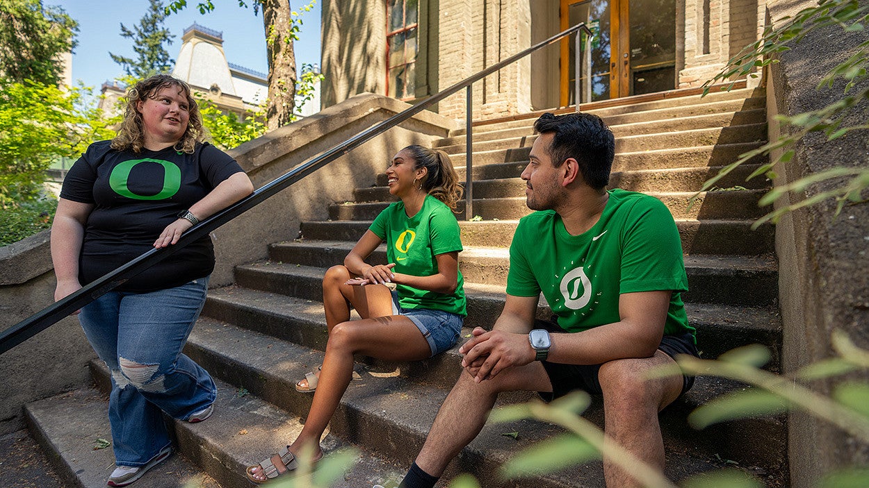 Students having a conversation on the steps of an building on campus